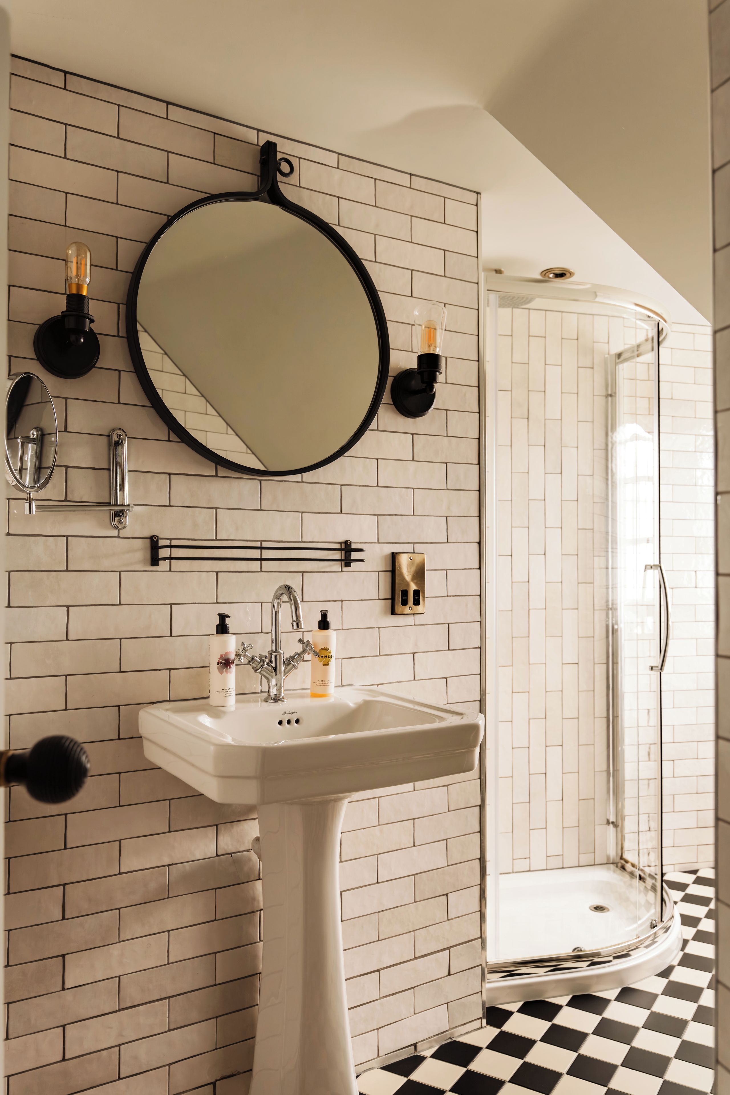 A bathroom with a white sink, a mirror, and a shower.