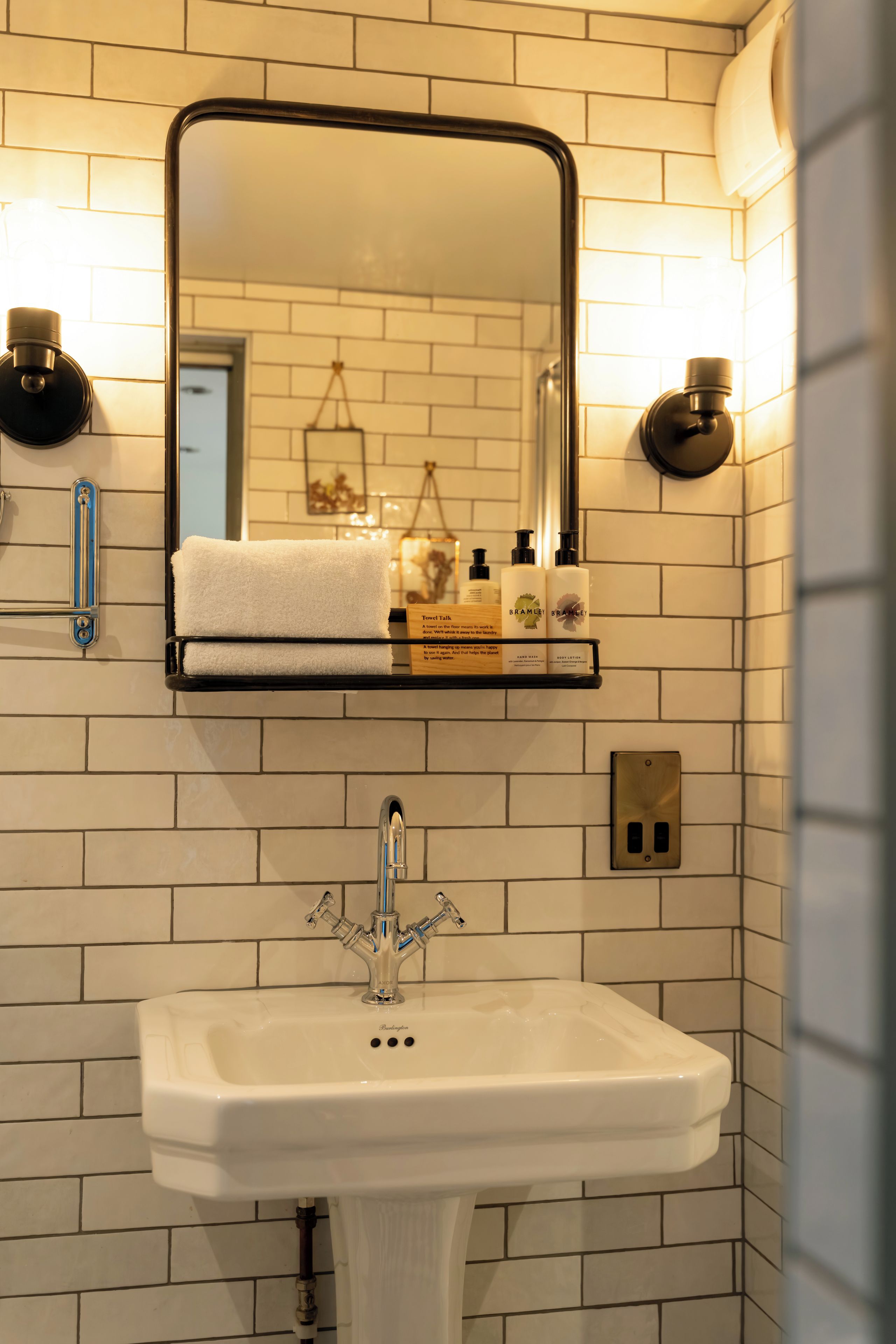 A bathroom with a white sink, a mirror, and a towel rack.
