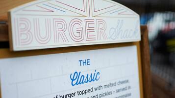 Un letrero para un puesto de hamburguesas que muestra las palabras 'BURGER' y 'THE Classic'.