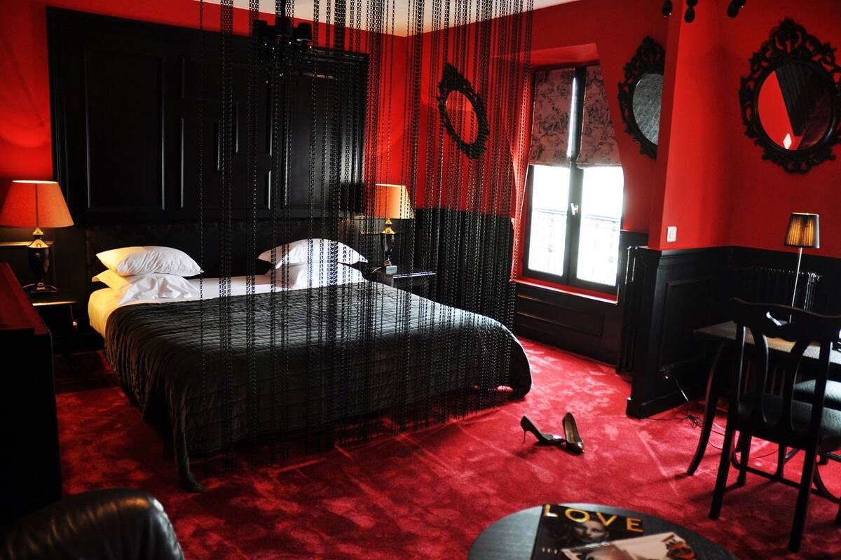 A room with a large bed, a desk, and a chair.