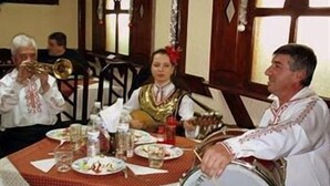 Una mesa de comedor con platos, vasos y una botella.