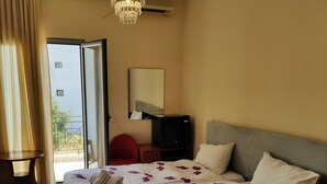 A hotel room with a bed, a TV, a chair, and a balcony. - King Lodge (Kalabaka)