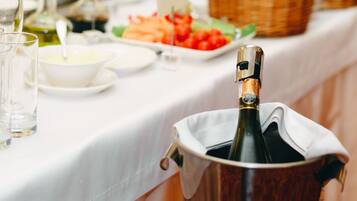 Une table avec une bouteille de champagne dans un seau à glace, entourée de différents plats et de verres.
