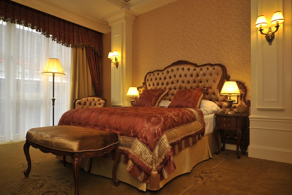 A spacious bedroom with a large bed, two bedside tables, and a nightstand.