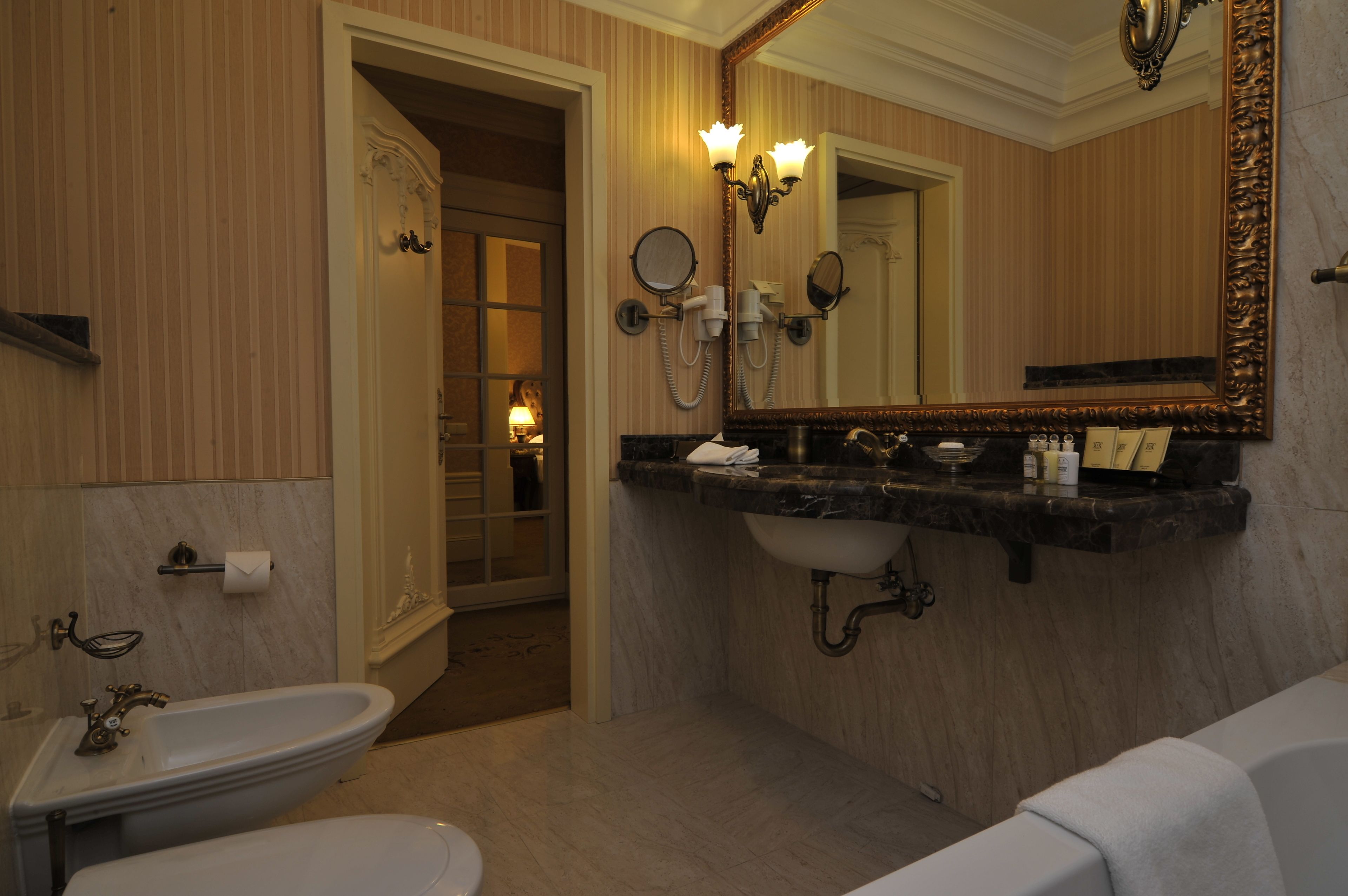 A bathroom with a sink, mirror, and toilet.