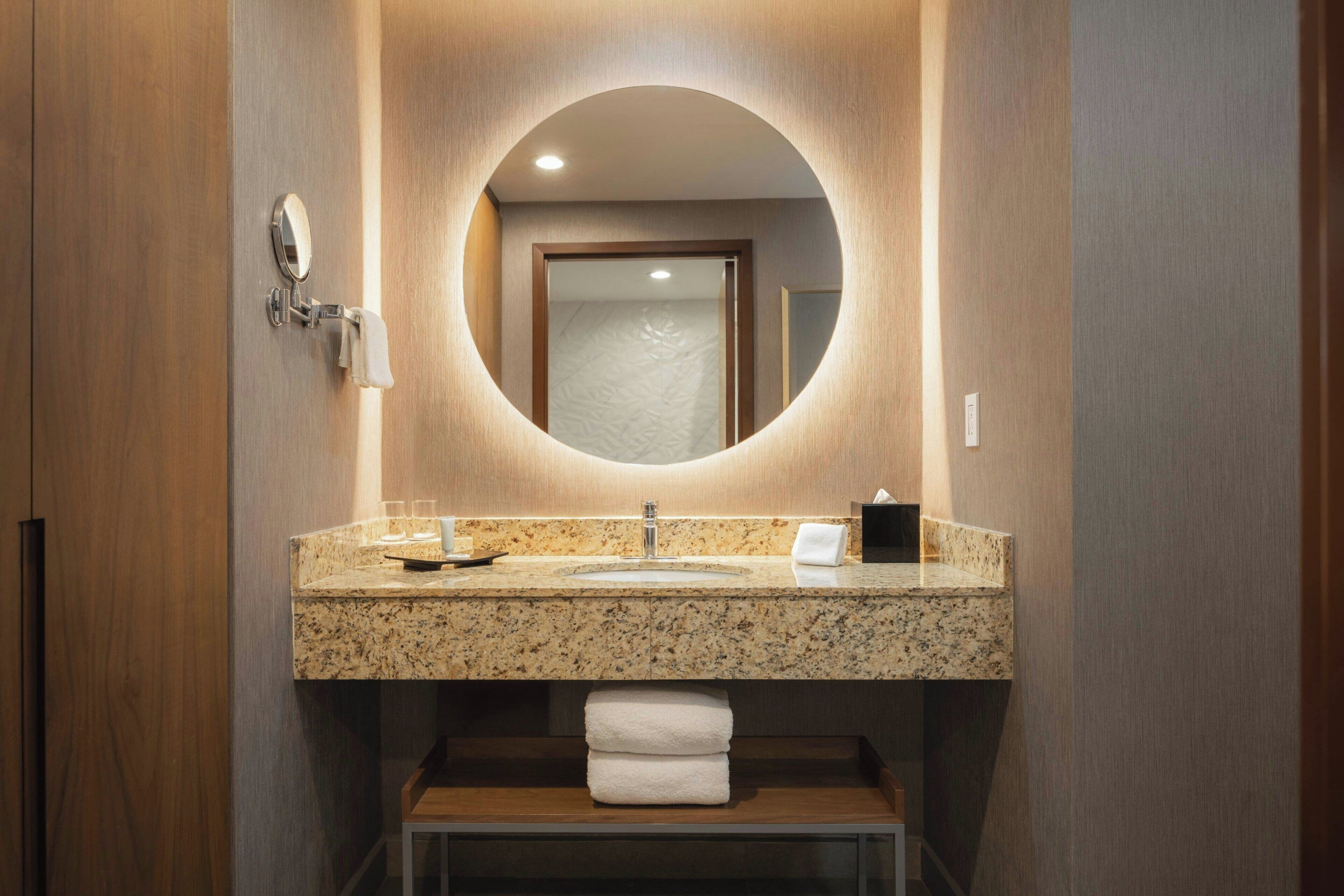 Une salle de bain avec un lavabo en granit, un miroir et un porte-serviettes.