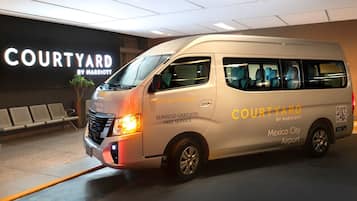 Una camioneta de Courtyard by Marriott estacionada frente a la entrada del hotel.