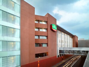 Un hotel moderno con fachada roja, ventanas amplias y un letrero de Marriott.