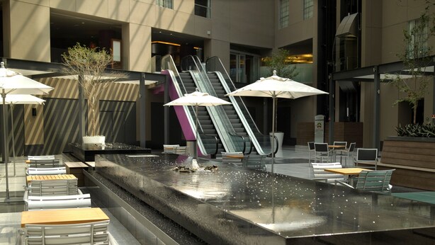 A modern outdoor seating area with a water feature, including a fountain and seating arrangements. - Courtyard Mexico City Airport (Mexico City)