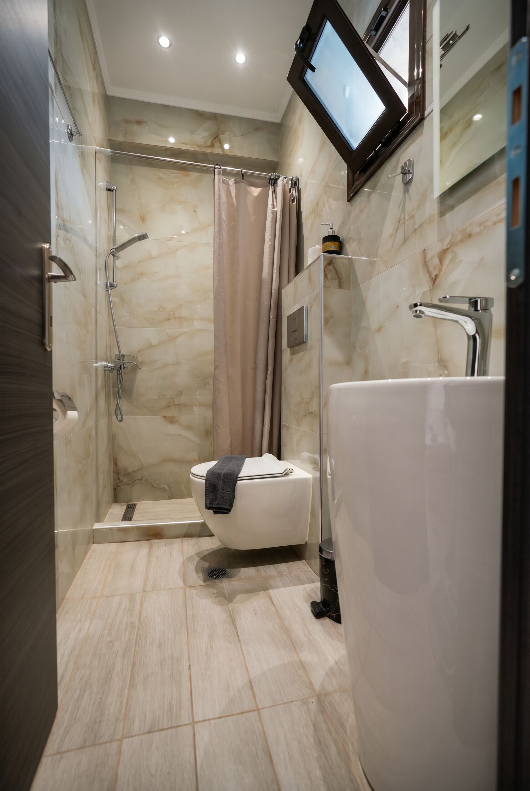 A modern bathroom with a walk-in shower, a toilet, and a bathtub.