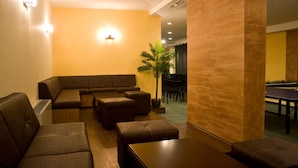 A modern lounge area with a sectional sofa, individual seating, a small table, and a plant. - Kamelia (Smolyan)