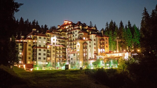 A multi-story hotel with a central courtyard, surrounded by trees. - Kamelia (Smolyan)