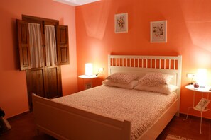A bedroom with a bed, two bedside tables, a nightstand, a wooden wardrobe, and two wall-mounted pictures. - Hostal La Posada del Recovero (Genalguacil)