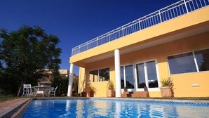 A two-story building with a balcony, a swimming pool, and outdoor furniture. - Villa Moringa Guesthouse (Windhoek)
