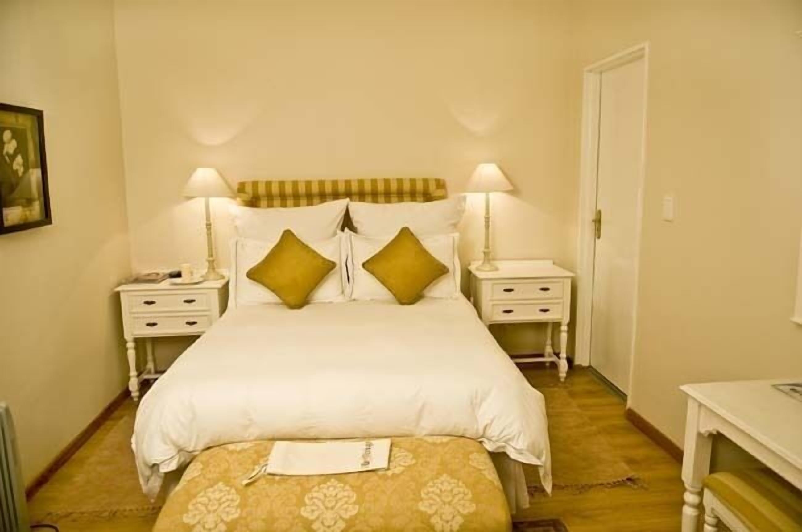 A neatly arranged bedroom with a bed, two bedside tables, and a nightstand.