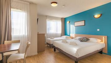 A hotel room with two beds, a desk, and a chair.