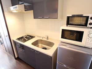 Kamer | Privékeuken | Een koelkast met diepvriezer, een microgolfoven, een oven, een kookplaat