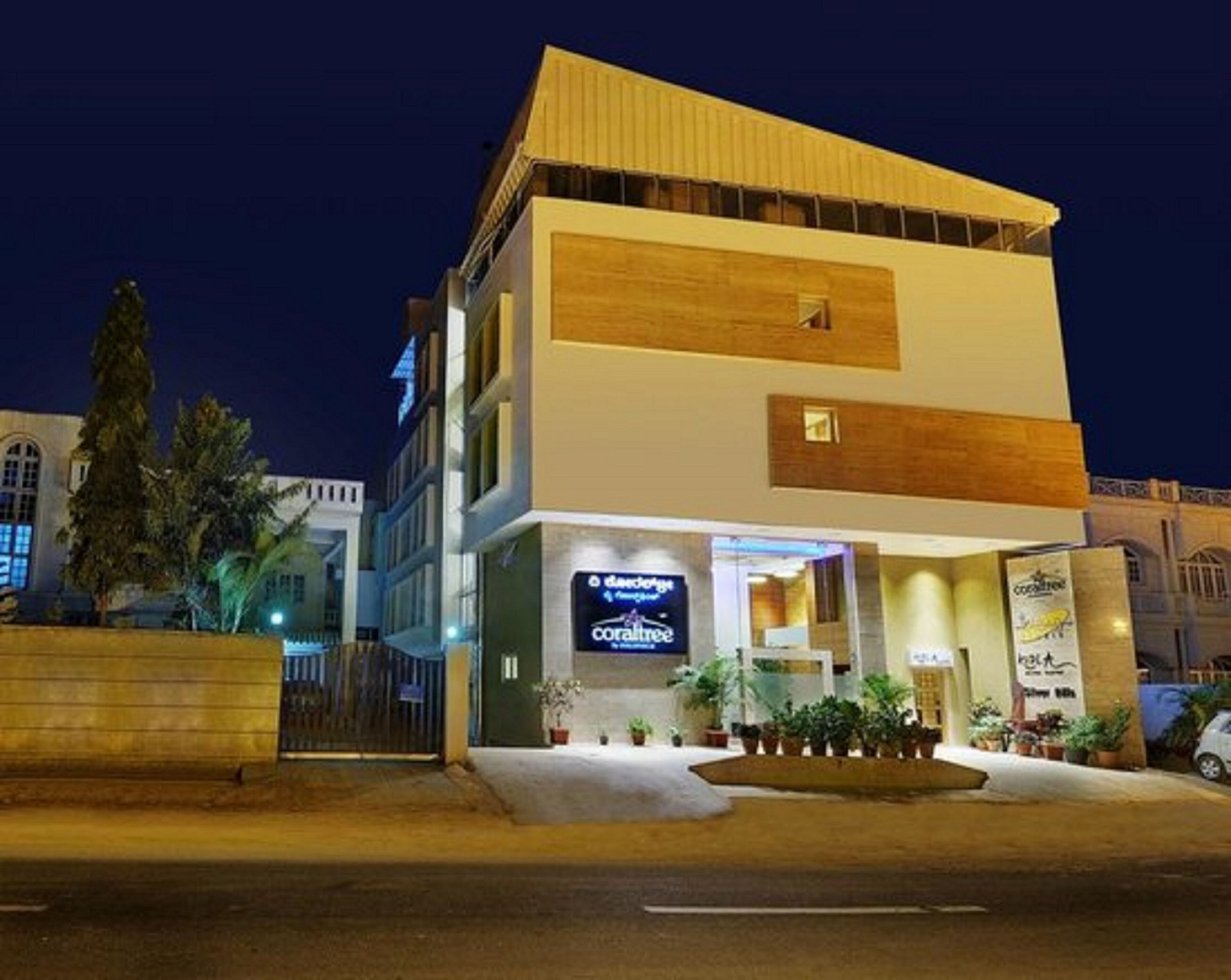 Un hotel moderno de dos pisos, con una entrada destacada y una fachada bien iluminada.