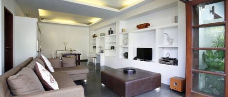 A modern living room with a sofa, a coffee table, and built-in shelves with decorative items.
