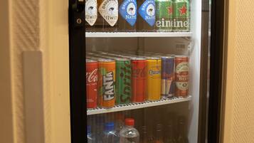 Un distributeur automatique de boissons contenant une variété de boissons, notamment des canettes de Heineken, du Fanta, du Coca-Cola et d’autres boissons.