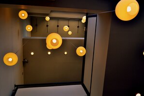 A room with a bed, a ceiling light fixture, and a wall-mounted shelf. - Plaza Paradiso by Camberland (Chacras de Coria)