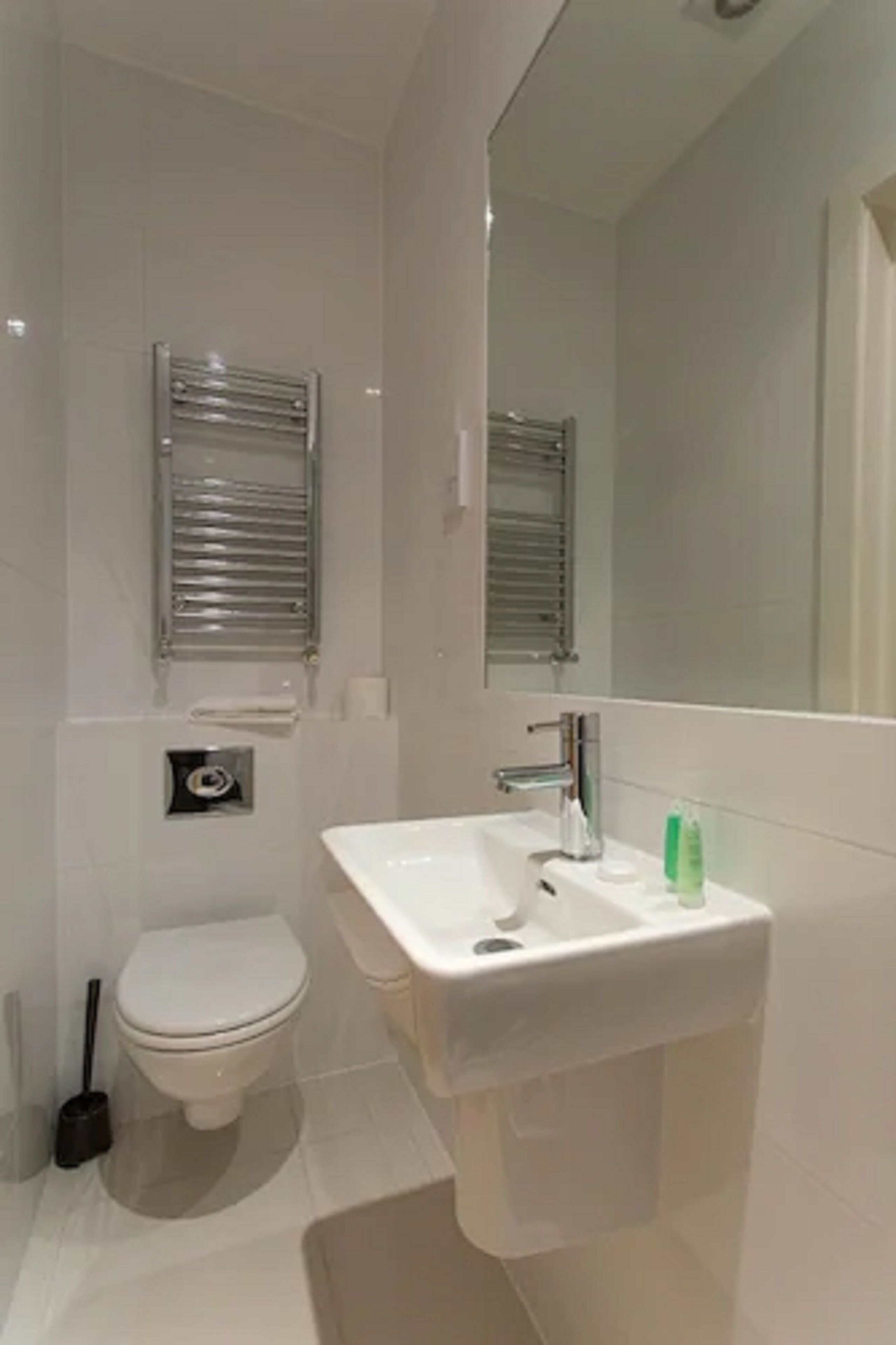 A modern bathroom with a toilet, sink, and mirror.