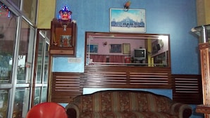 Una sala de estar con un sofá, un televisor y un ventilador de techo.