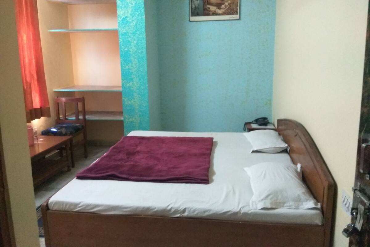 Un dormitorio con una cama, un escritorio y una silla.