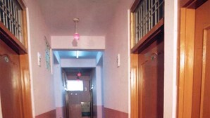 Un pasillo con puertas de madera y suelo de mármol.
