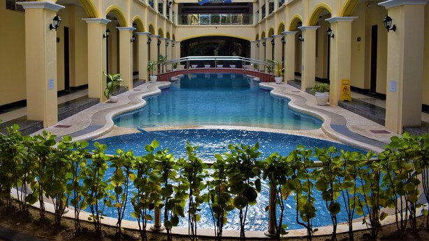 A hotel atrium with a central pool, multiple balconies, and a sign for the Golden Phoenix Hotel. - Golden Phoenix Hotel Boracay (Boracay Island)