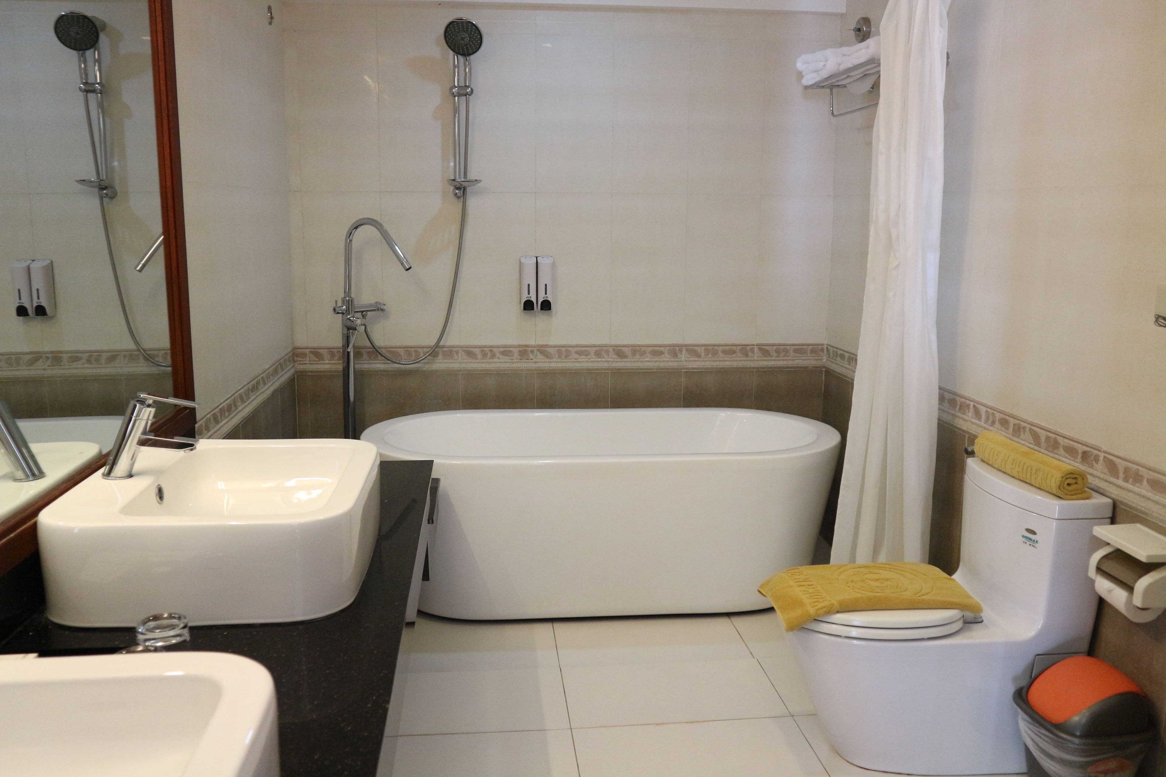 Un baño con bañera, lavamanos, inodoro y ducha.