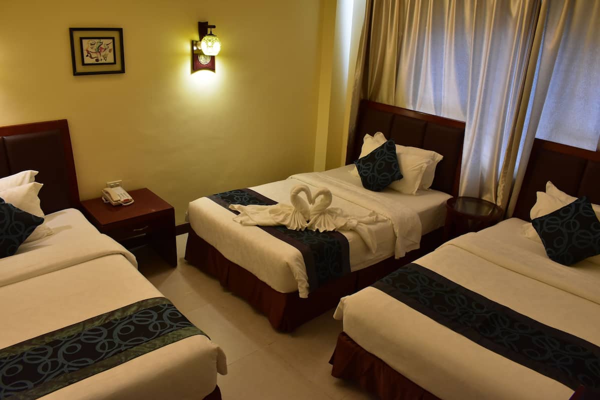 Triple Family Room | Minibar, in-room safe, individually furnished, desk