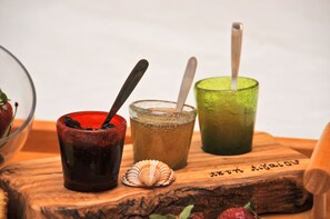 Three glasses of different colored drinks on a wooden board with a shell and a spoon.