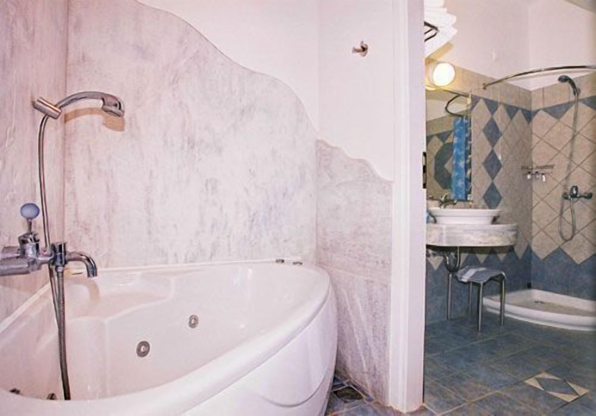 A bathroom with a freestanding bathtub, a shower area, and a sink.