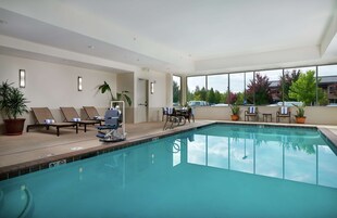 Una piscina techada, sillones reclinables de piscina