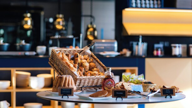 A buffet with various food items and a bottle of maple syrup.