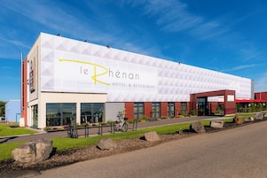A modern hotel with a geometric facade, large windows, and a prominent logo.