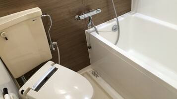 Un baño moderno con inodoro, bañera y ducha.