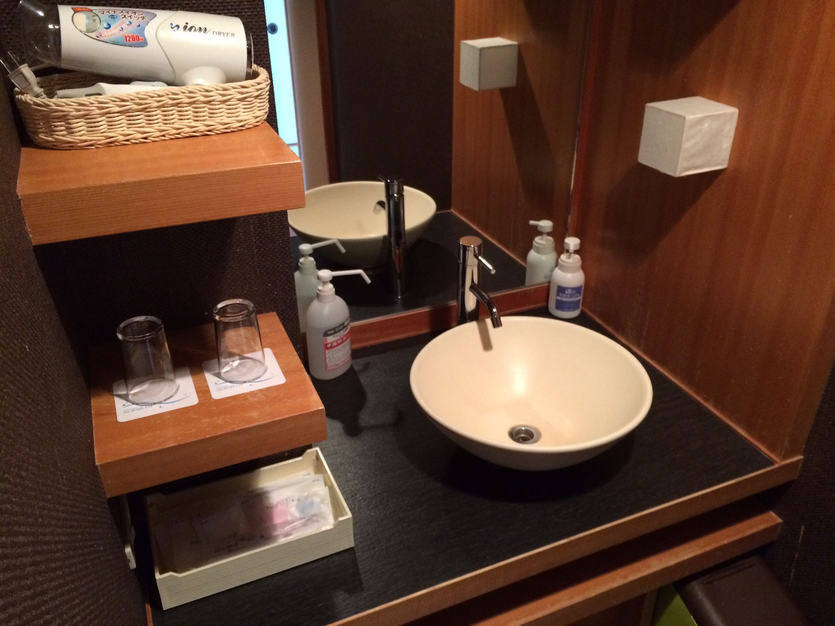 A bathroom with a sink, mirror, and toiletries.