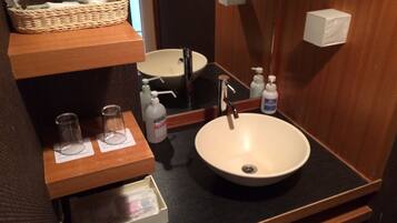 A bathroom with a sink, mirror, and toiletries.