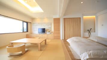 A modern hotel room with a large bed, a wooden desk, a television, and a view of the outside.