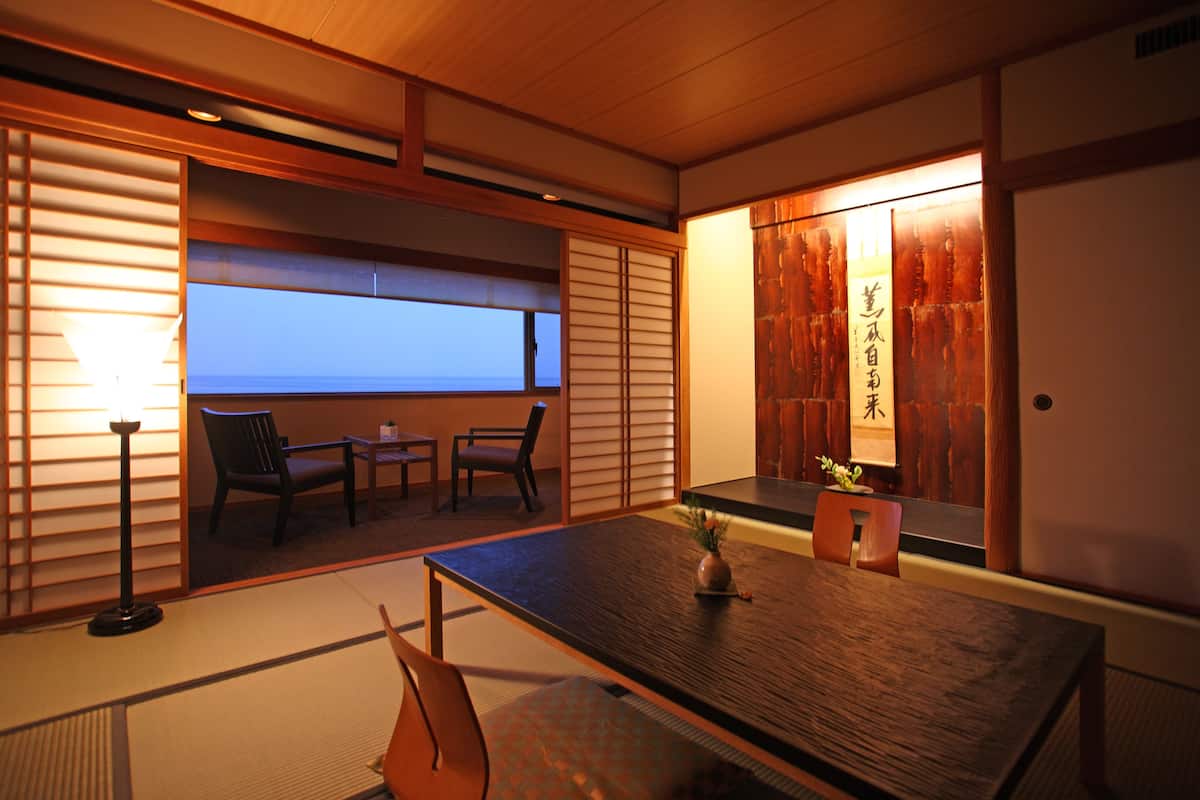 Ein traditioneller japanischer Raum mit Tatami-Böden, einem niedrigen Tisch und Schiebetüren.