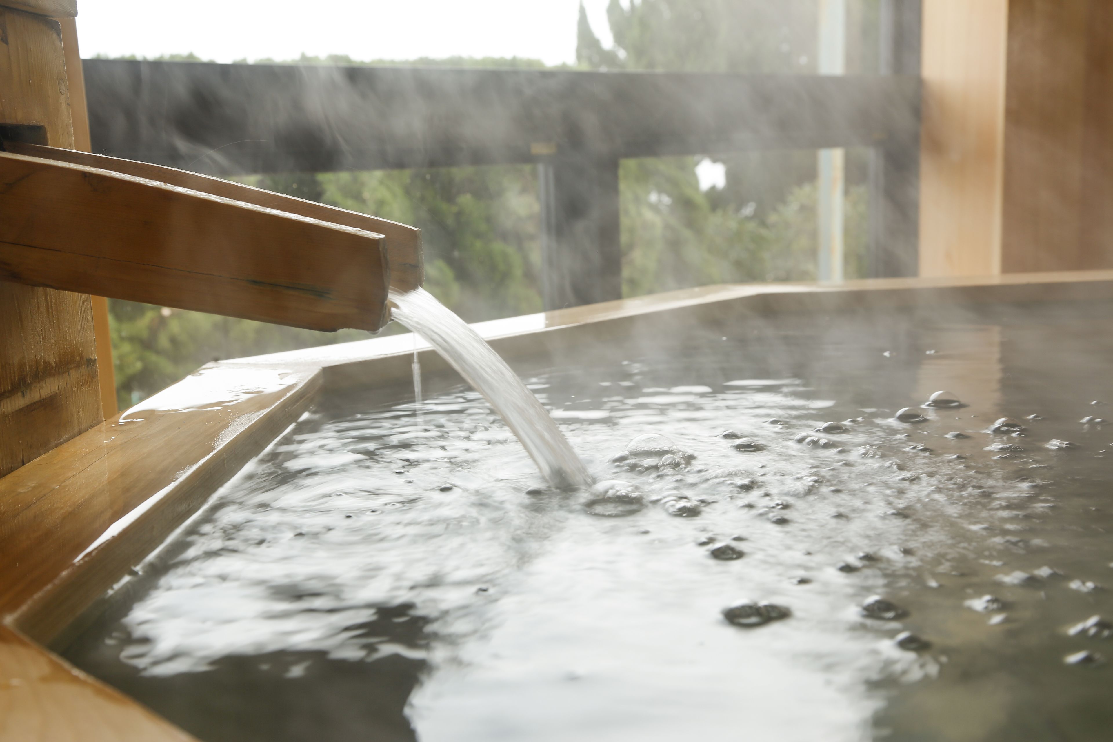 Una bañera de madera con agua fluyendo.