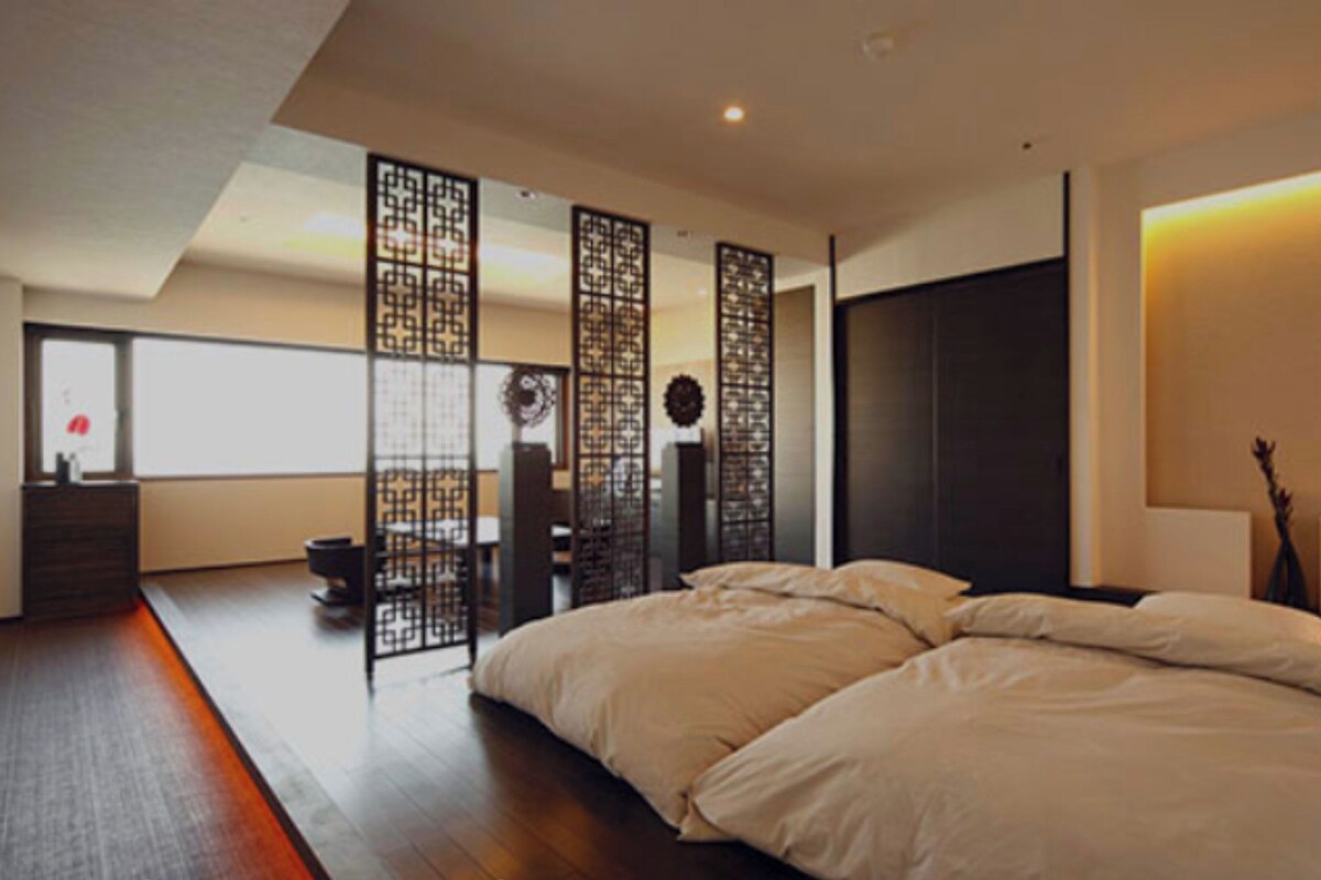 Een moderne slaapkamer met een groot bed, houten vloeren en een decoratieve wand.