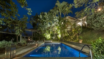 Een buitenzwembad, parasols bij het zwembad en ligstoelen