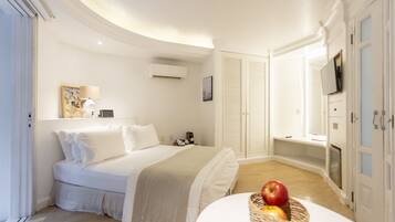 A bedroom with a bed, bedside table, and a fruit basket.