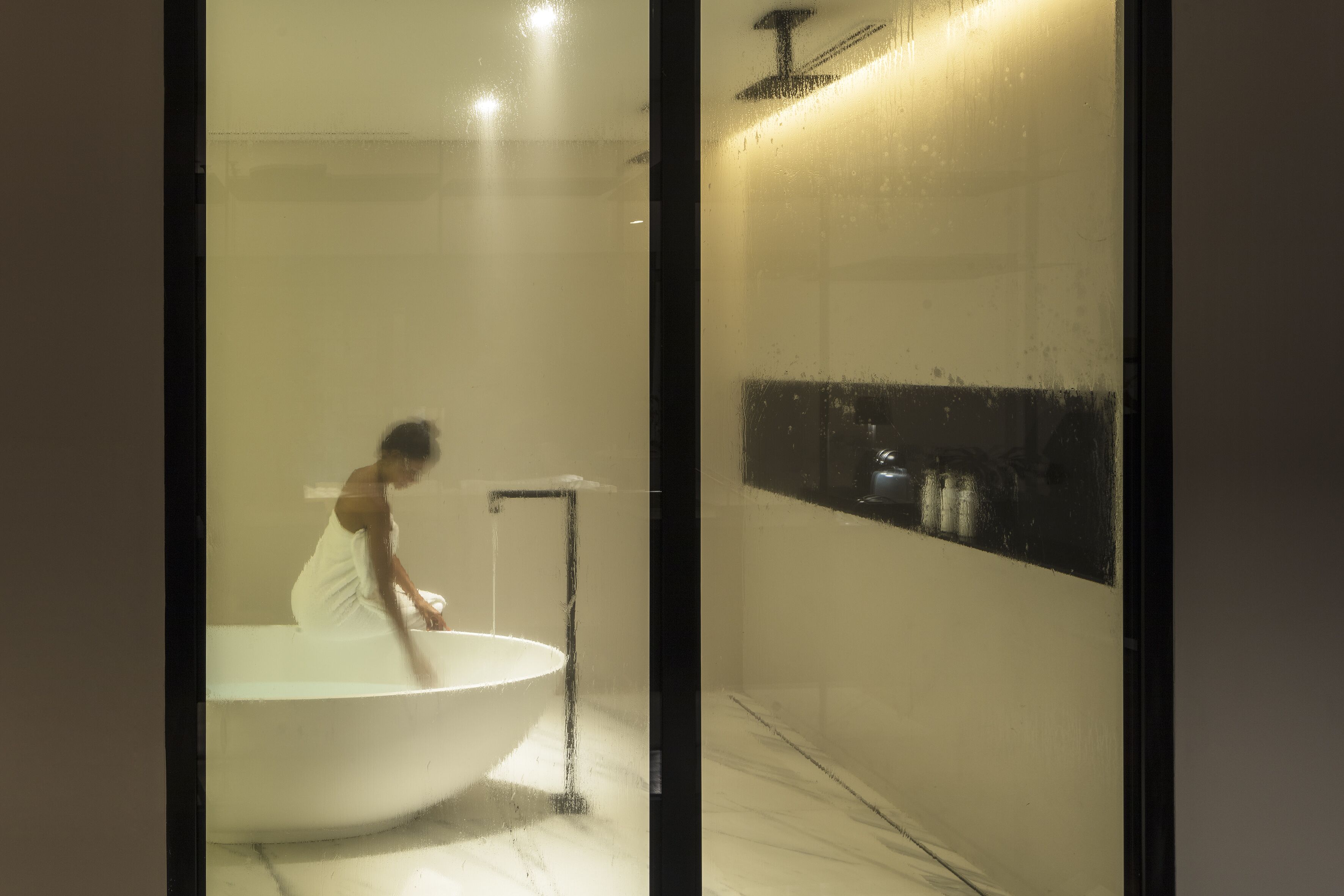 A bathroom with a large bathtub, a shower, and a mirror.
