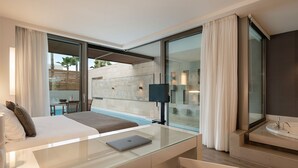Una habitación de hotel moderna con escritorio de vidrio, cama, ordenador portátil, ventana grande y baño con bañera.