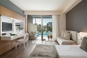 A modern hotel room with a large bed, a desk, a sofa, and a view of a swimming pool.