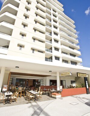 A hotel with multiple balconies, outdoor seating, and a sign for 'Shingle Inn'.